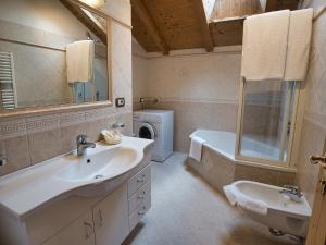 ein Badezimmer mit einem Waschbecken, einem WC und einer Badewanne in der Unterkunft Aparthotel Monte 44 in Wolkenstein in Gröden