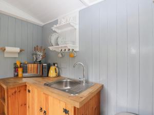 cocina con fregadero y encimera de madera en Rabbit Hill Hut, en Abergavenny