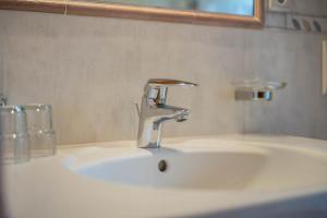 a bathroom sink with a faucet and a mirror at Mitterbruggehof Apt Silberdistel in Anterselva di Mezzo