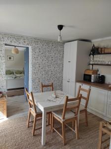 uma cozinha com mesa e cadeiras num quarto em Szomolyai Vadvirág vendégház em Szomolya