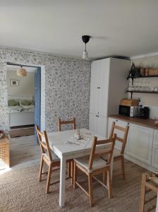 a kitchen with a table and chairs in a room at Szomolyai Vadvirág vendégház in Szomolya