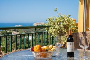 un tavolo con una bottiglia di vino e un cesto di frutta di BLONZU SUDÁFRiCA a Benalmádena