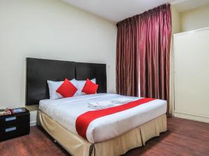 a bedroom with a large bed with red pillows at Al Ferdous Hotel Apartment in Sharjah