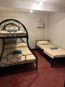 a room with two bunk beds in it at Little John's Town Inn in Coron