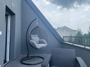 a porch with a hanging chair with a pillow at Exclusive Apartments with Private Parking and a Gym in Kraków