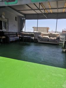 a living room with a green floor and couches at JERDOUH For FAMILY ONLY in Tétouan