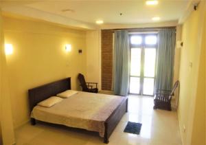 a bedroom with a bed and a large window at Thalalla Ocean View in Dickwella