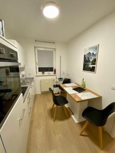 a kitchen with a desk and chairs in a room at Stilvolle Ferienwohnung mit Stellplatz WLAN free Netflix Nähe Bahnhof in Zwickau