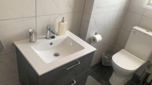 ein Bad mit einem Waschbecken und einem WC in der Unterkunft Prestige Worldwide Apartments in Ayia Napa