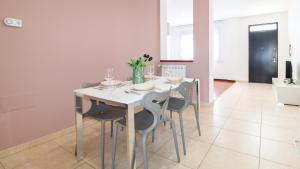 una sala da pranzo con tavolo e sedie bianchi di Welcomely - Xenia Boutique Tirso a Oristano