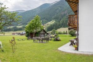 a picnic table in a field with mountains in the background at Mitterbruggehof Apt Alpenrose in Anterselva di Mezzo