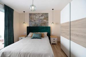 une chambre avec un grand lit avec une tête de lit verte dans l'établissement Villa Alegría, à Chiclana de la Frontera