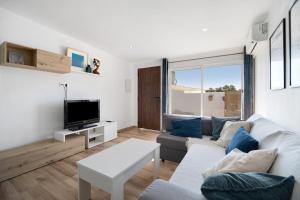 un salon avec un canapé et une télévision dans l'établissement Villa Alegría, à Chiclana de la Frontera