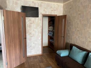 a living room with a couch and a tv on a wall at Podobovo Horbatko 250м від моря in Yuzhne