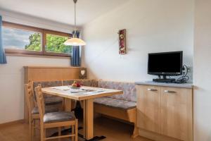 ein Wohnzimmer mit einem Tisch und einem TV in der Unterkunft Woehrmannhof Apt Birnblüte in Feldthurns