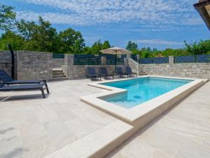 a patio with a swimming pool and a stone wall at Holiday Home Pahari by Rent Istria in Roč