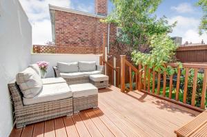 een terras met een bank en stoelen bij Seaside king room in cozy house self check-in fast WiFi in New Brighton