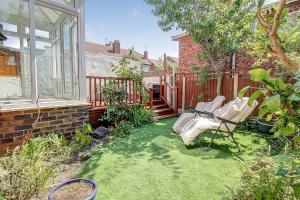 een tuin met twee stoelen op het gras bij Seaside king room in cozy house self check-in fast WiFi in New Brighton