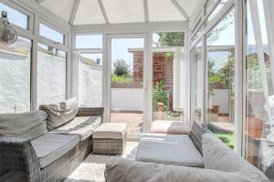 een afgeschermde veranda met banken en ramen bij Seaside king room in cozy house self check-in fast WiFi in New Brighton