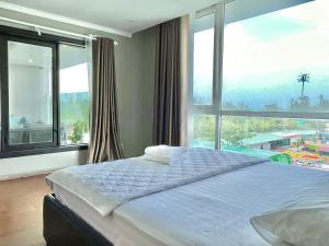 Un dormitorio con una cama grande con una ventana grande. en Nice Oasky Vung Tau Apartment 88, en Vung Tau 47 fotos más