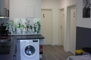 a kitchen with a washing machine in a room at Ahoi-Gästehaus in Hamburg