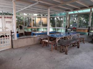 車城鄉的住宿－墾丁海生館-海泊旅宿，一间设有两张乒乓球桌和长凳的房间