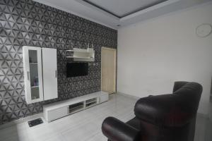 sala de estar con silla y espejo en OYO 92714 Miracle Kost, en Manado