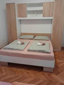 two beds in a room with wooden floors at Apartman Larus in Starigrad-Paklenica