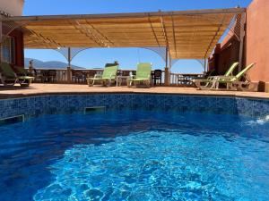 a swimming pool with chairs and a table at Hotel Nuevo Palas in Lanjarón