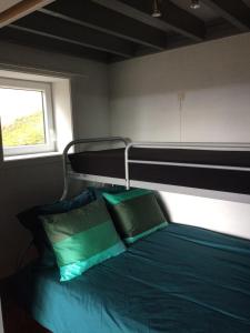 uma cama com almofadas verdes num quarto em vakantieverblijf Coo-sy em Stavelot