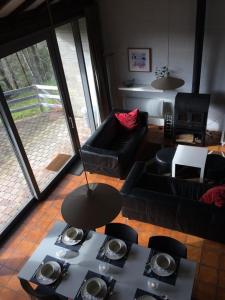 a living room with black couches and a table at vakantieverblijf Coo-sy in Stavelot