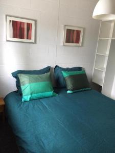 una camera da letto con letto con lenzuola e cuscini blu di vakantieverblijf Coo-sy a Stavelot