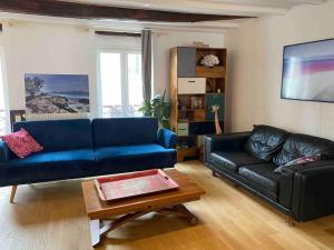 Appartement convivial proche du Canal Saint Martin في باريس: غرفة معيشة مع أريكة زرقاء وطاولة