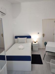a white and blue bed in a small room at Vista Panorâmica Amadora in Amadora