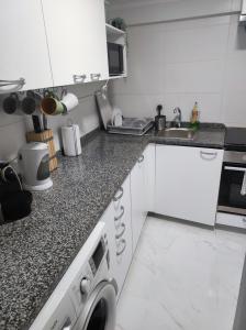 a kitchen with a sink and a washing machine at Vista Panorâmica Amadora in Amadora