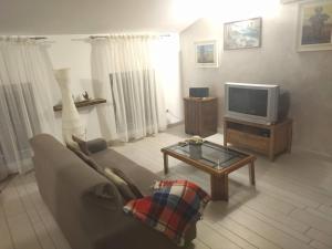 a living room with a couch and a tv at Room in Guest room - Double room between Padua and Chioggia in Brugine