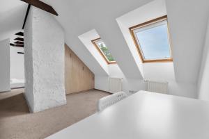a white room with a staircase and a window at Rynek Nowego Miasta Two-Level Apartment by BookingHost in Warsaw