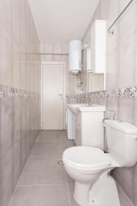 a white bathroom with a toilet and a sink at apartman 2 in Budva +11 photos