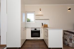 a white kitchen with a stove and a window at apartman 2 in Budva
