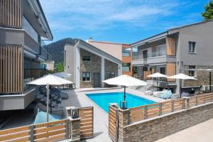 cortile con piscina e ombrelloni di Aerino Luxury Villas a Chrisi Ammoudia