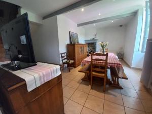 een woonkamer met een tafel en een eetkamer bij Maison avec jardin in Adé