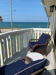 a balcony with chairs and a table and the ocean at Ormond Beach, fun & loving sun! in Ormond Beach