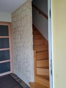 a staircase in a house with a stone wall at Charmant logement avec parking gratuit sur place in Barr