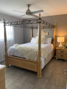 a bedroom with a canopy bed with a white comforter at Ormond Beach, fun & loving sun! in Ormond Beach