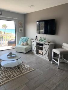 uma sala de estar com uma televisão de ecrã plano na parede em Ormond Beach, fun & loving sun! em Ormond Beach