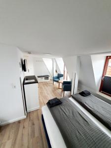 een slaapkamer met 2 bedden, een keuken en een woonkamer bij Hafen Appartements Wismar in Wismar