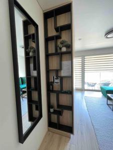 a mirror on a wall next to a living room at Modern & cozy studio with patio “Prie Juros” in Palanga