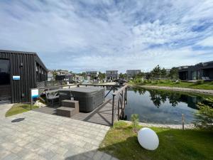 a house with a dock and a body of water at Modern & cozy studio with patio “Prie Juros” in Palanga