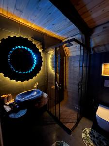 ein Bad mit einer Dusche, einem Waschbecken und einem Spiegel in der Unterkunft Sisorti süit bungalov in Rize