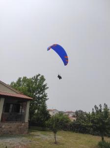 un cerf-volant volant dans le ciel au-dessus d'une maison dans l'établissement La casa de la parcela, à Piedrahíta